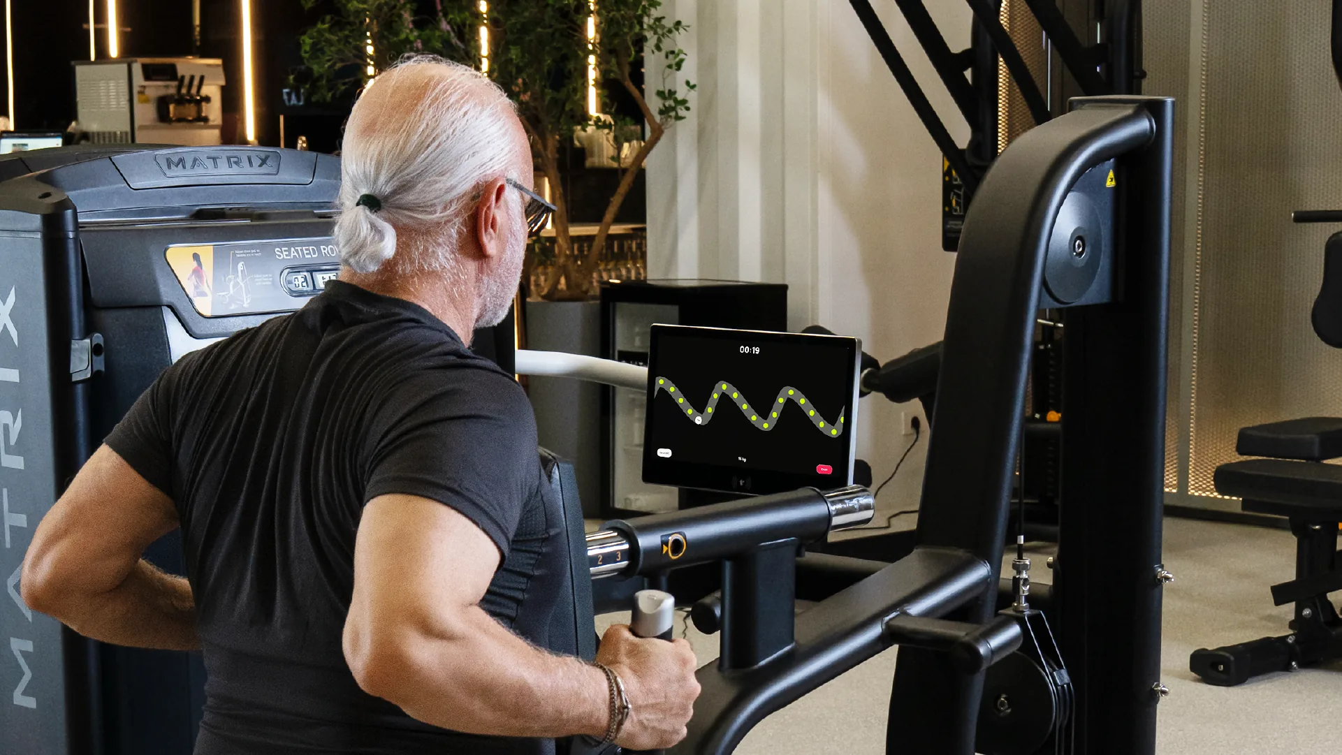 Mitglied trainiert an einer Rudermaschine mit Trackbar