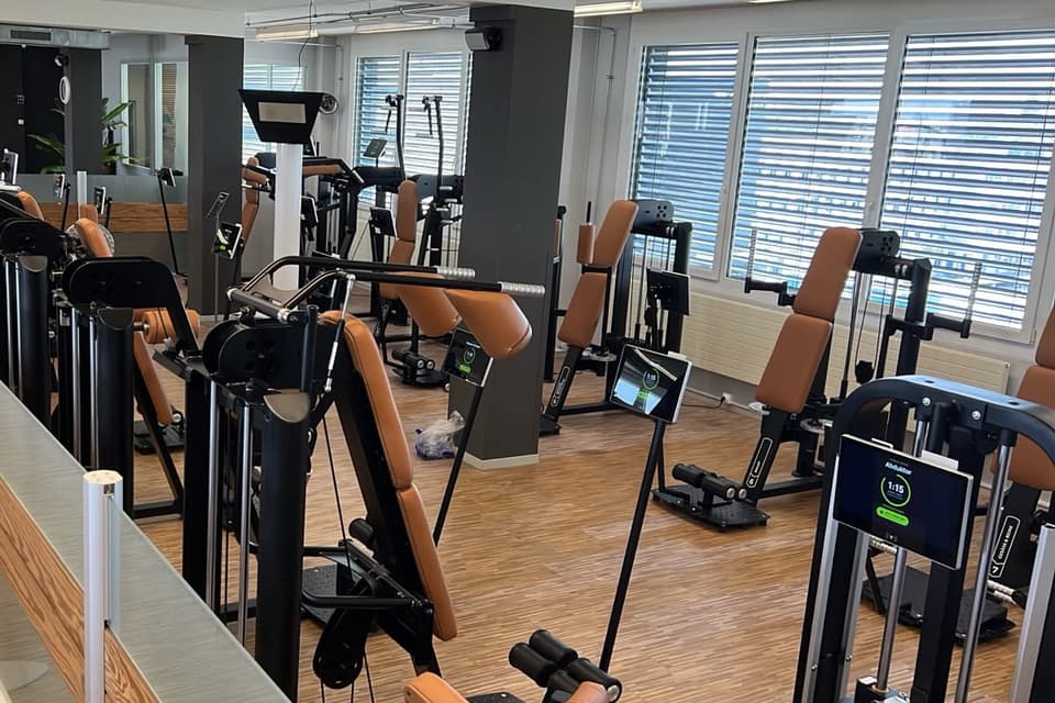 Circuit training area in a gym: several strength machines retrofitted with Trackbar tablets.